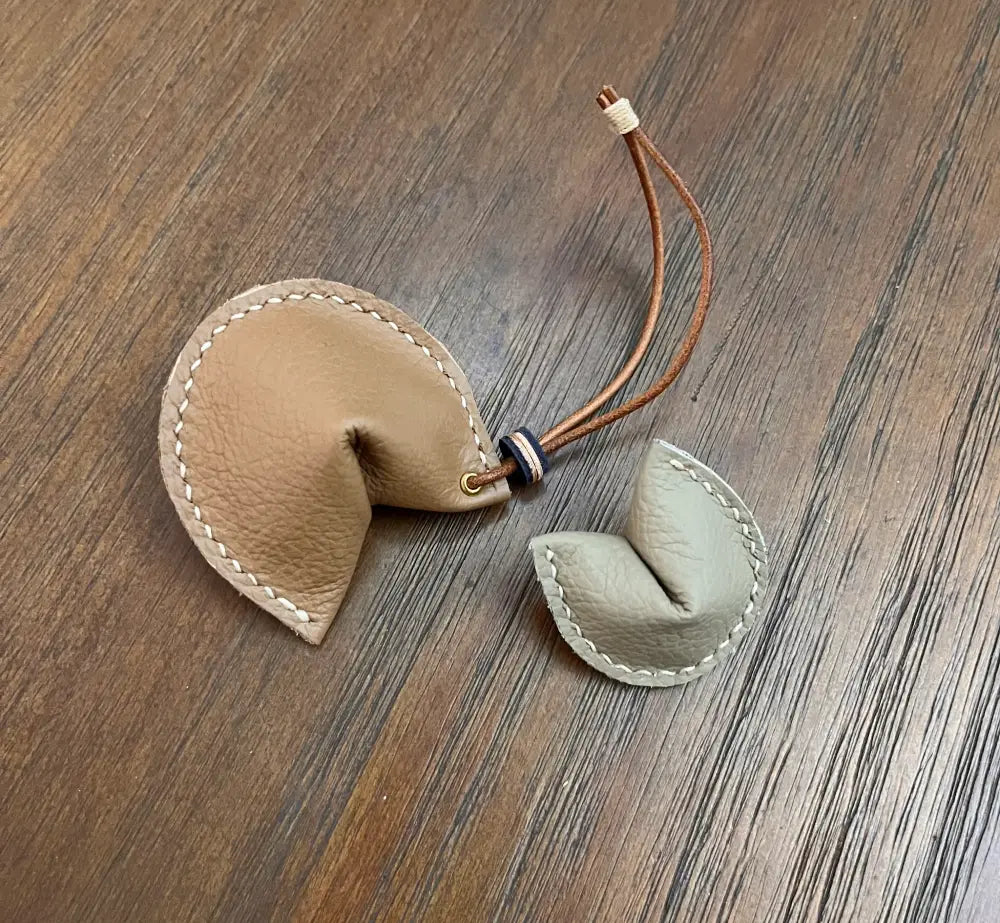 Close-up of white wax thread stitching on a brown leather edge.