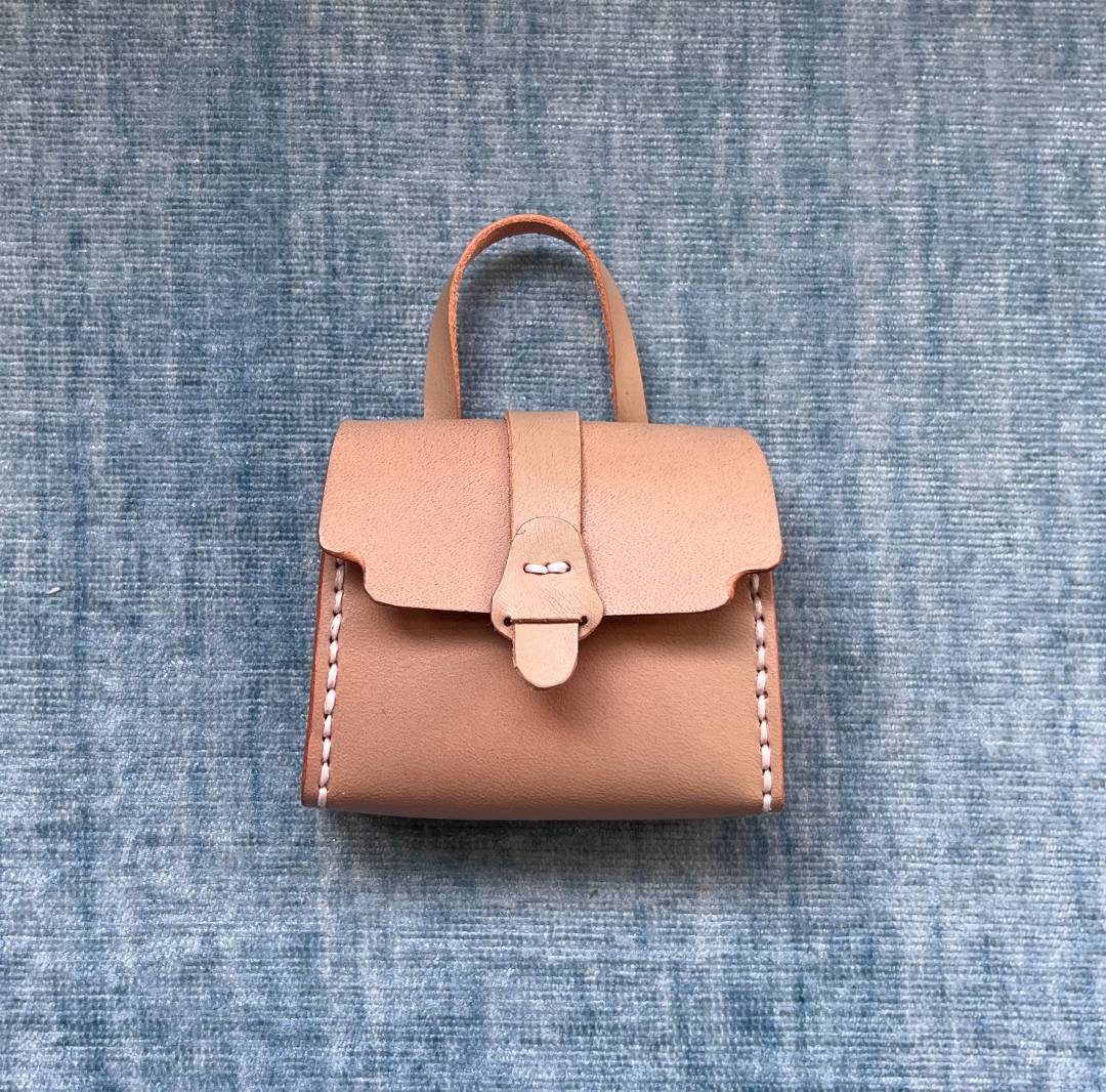 DIY leather bag charm on a textured blue background