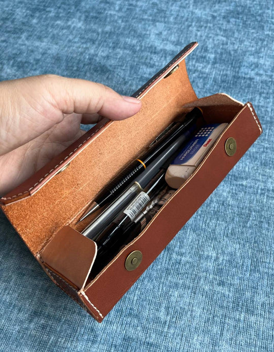 Top-down view of open leather case with brass magnetic clasp.