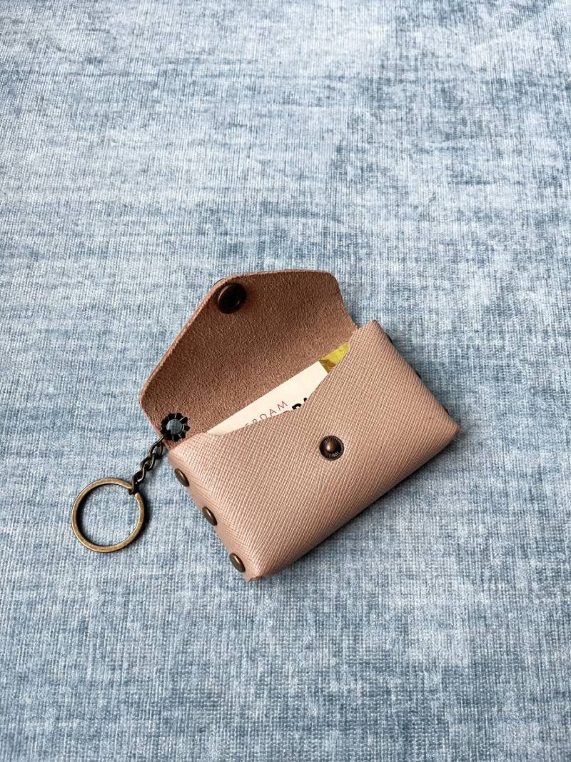 Leather pieces, Chicago screws, and 10mm snaps laid out for DIY project.