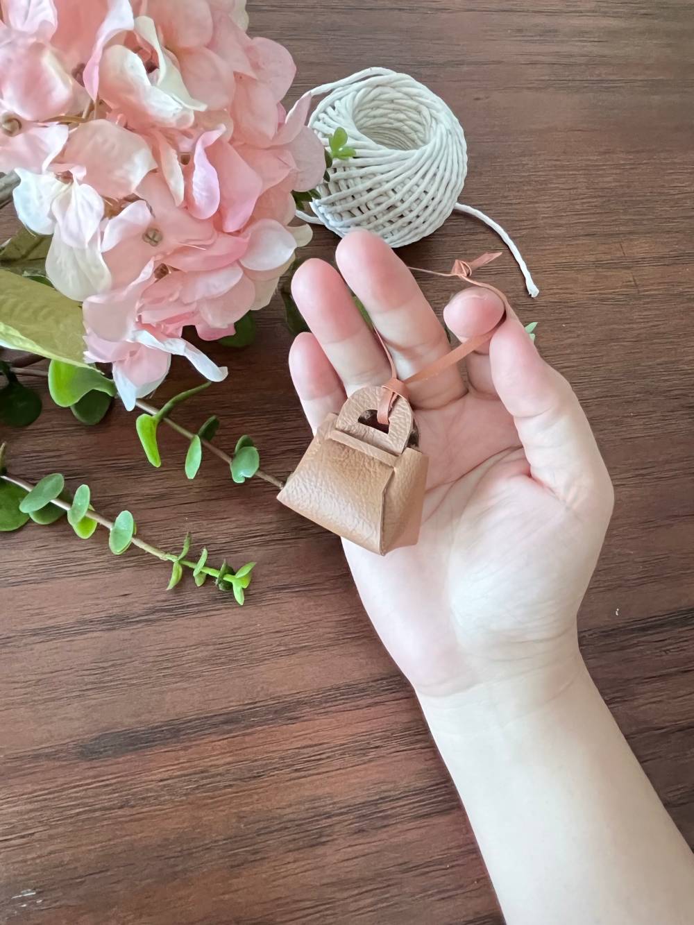 Miniature leather bag charm showing front view.