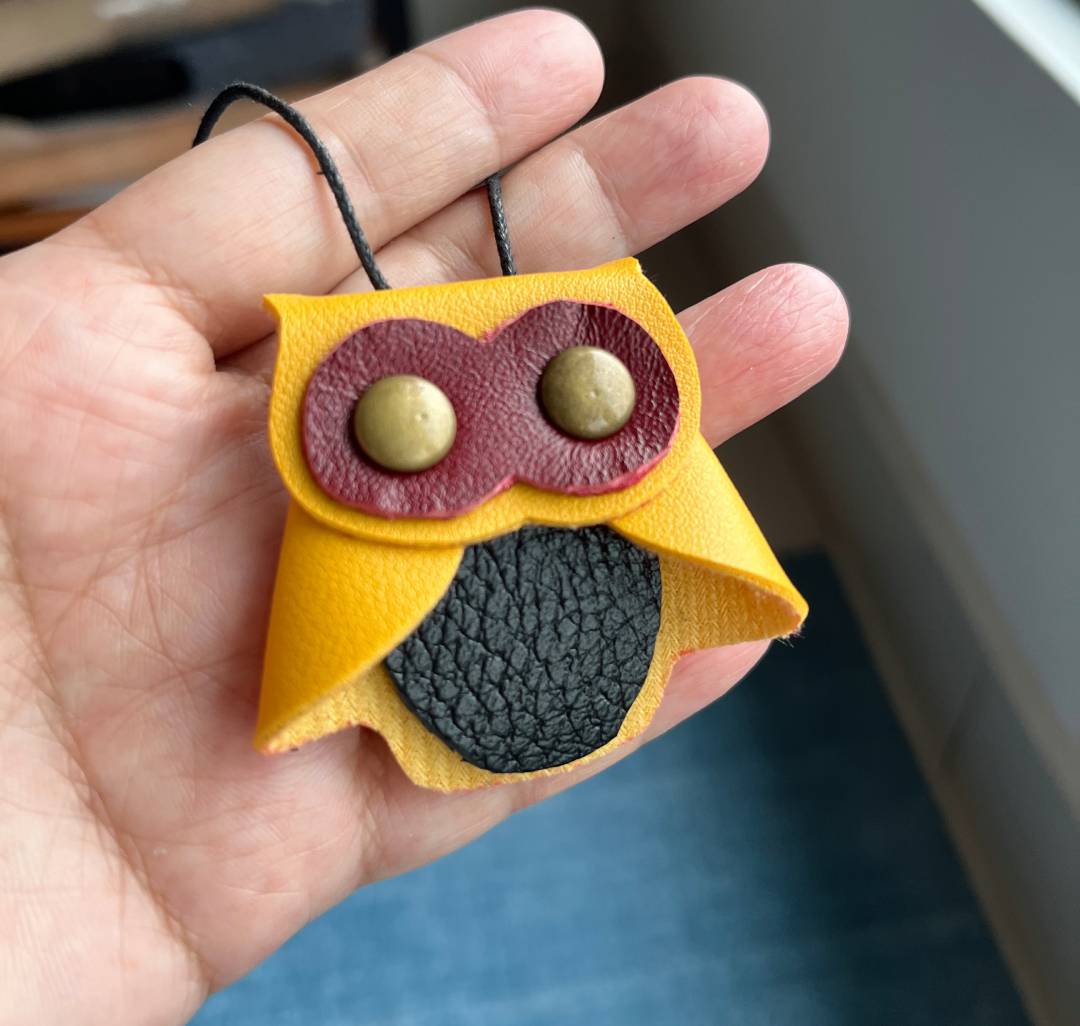 Close up of a handmade leather owl key organizer measuring 5x5cm with rivet details.