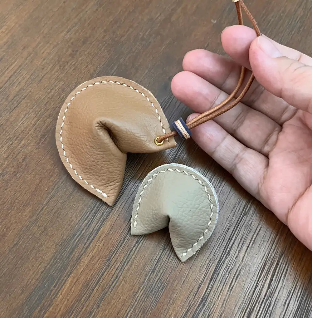 Close-up of white wax thread stitching on a brown leather edge.