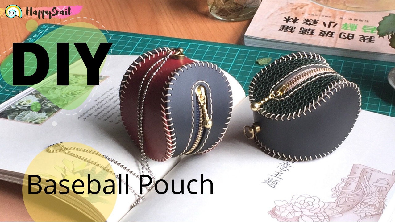 Two DIY baseball pouches with zipper closures. One pouch is red and black, the other is green and black. Both pouches have white stitching around the edges.