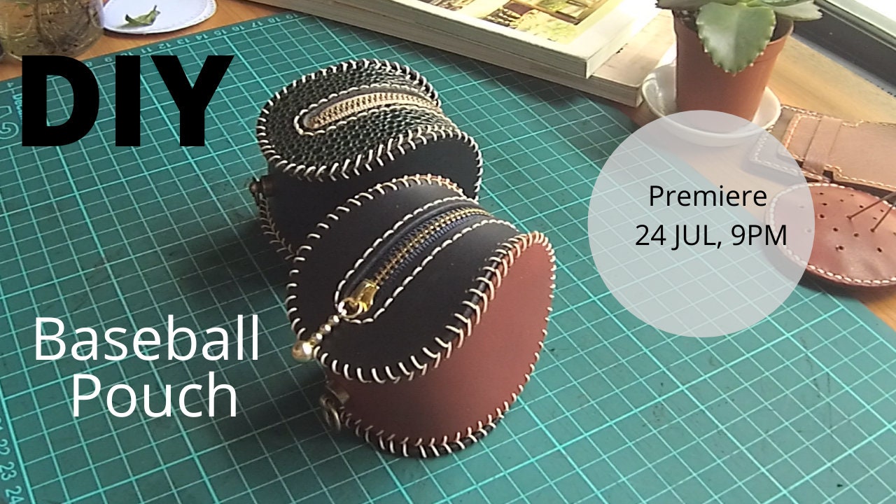 DIY Baseball Coin Pouch, a craft project featuring two leather pouches with zips and decorative stitching. The pouches are on a green cutting mat.