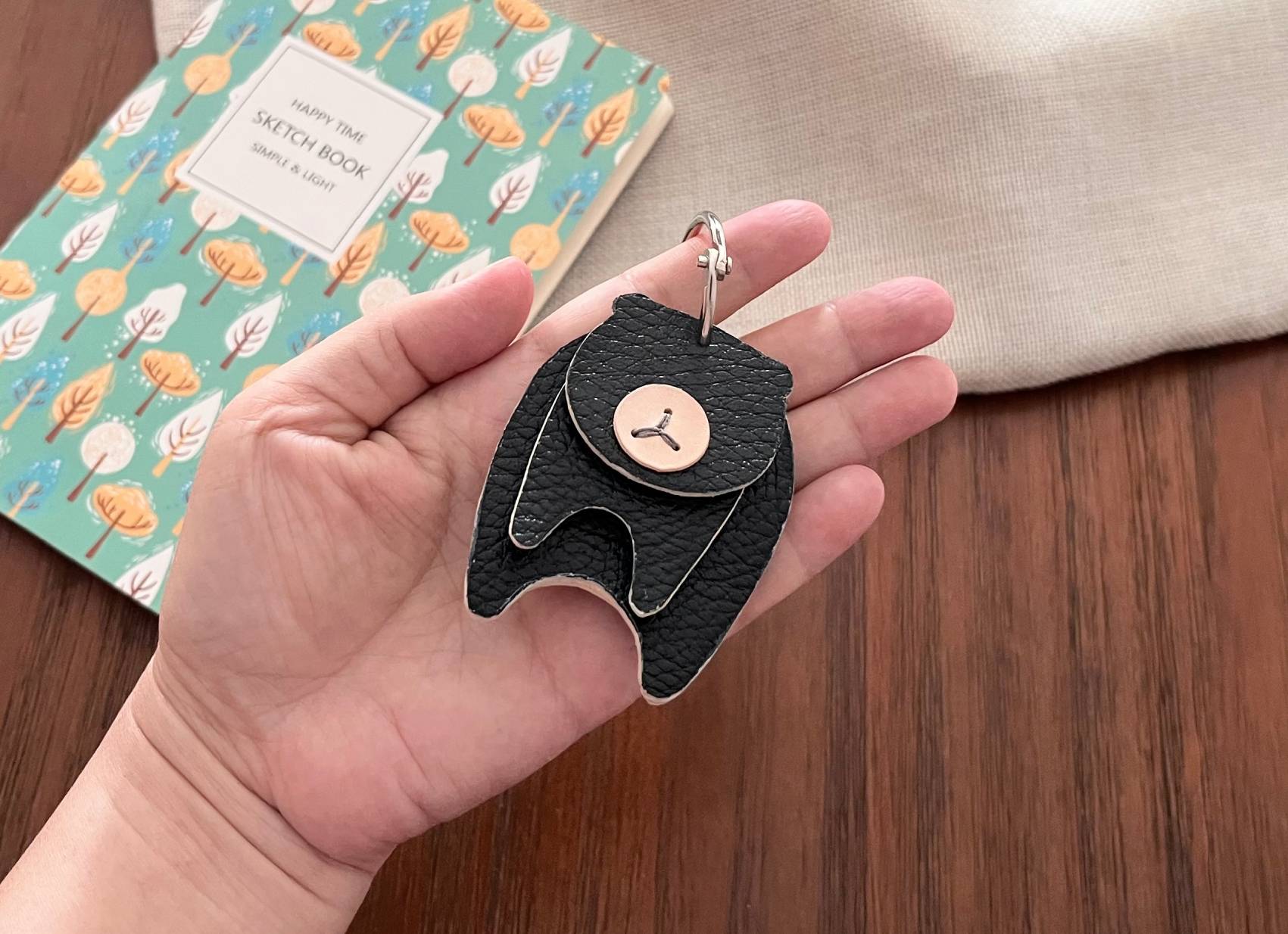 Sleek black pebble-grain leather bear pendant for modern minimalist style.