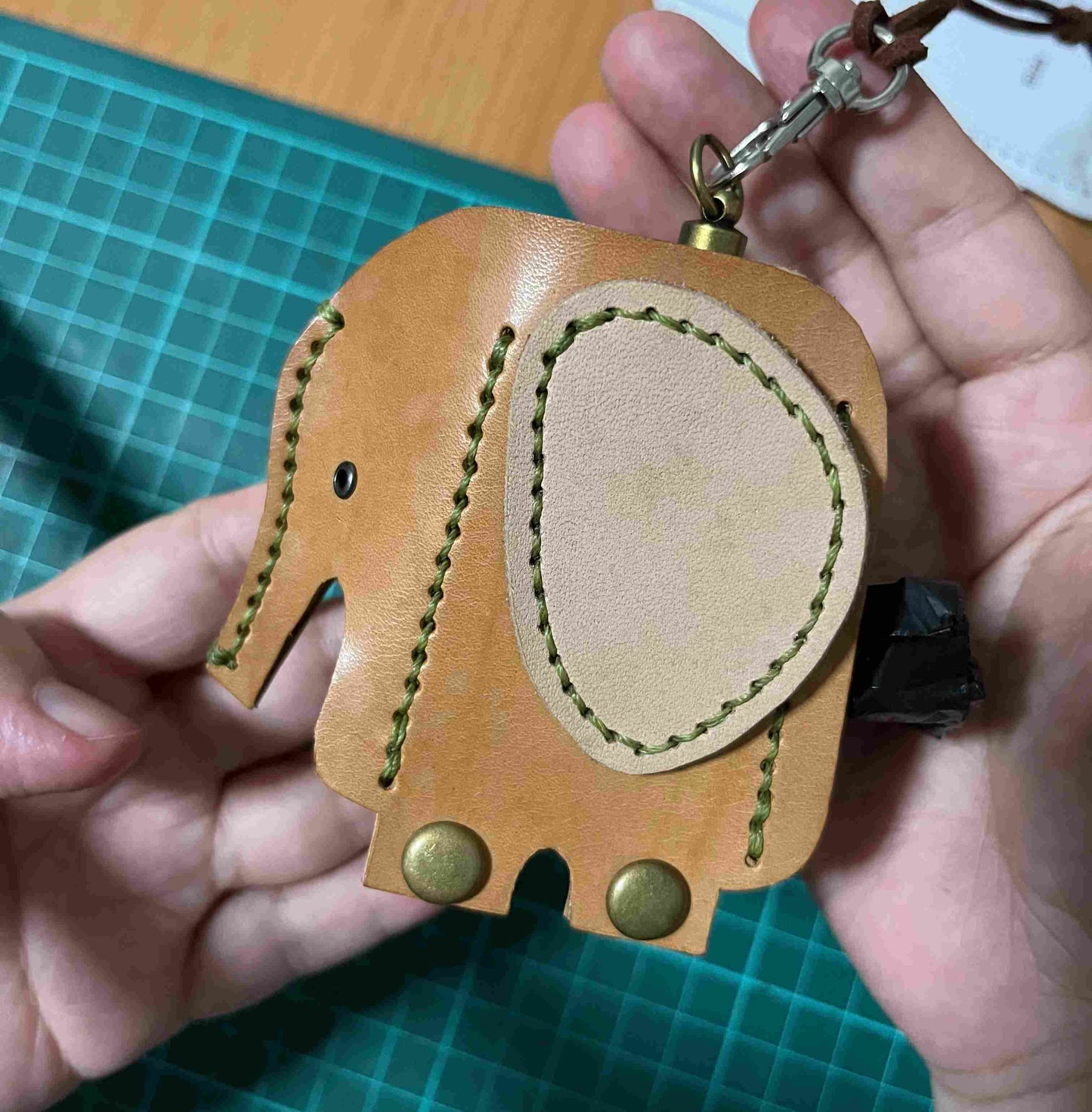 Unique elephant-shaped leather bag dispenser hanging in a boutique retail setting.