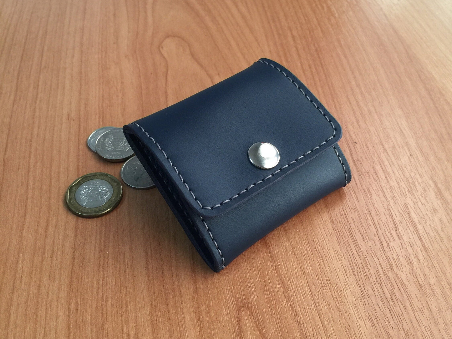 Vegetable tanned leather coin purse with silver snap button closure.