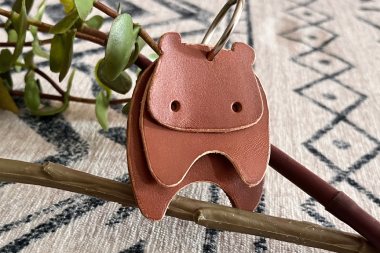 Stylized leather hippo keychain in a rich mahogany brown with layered head detail.