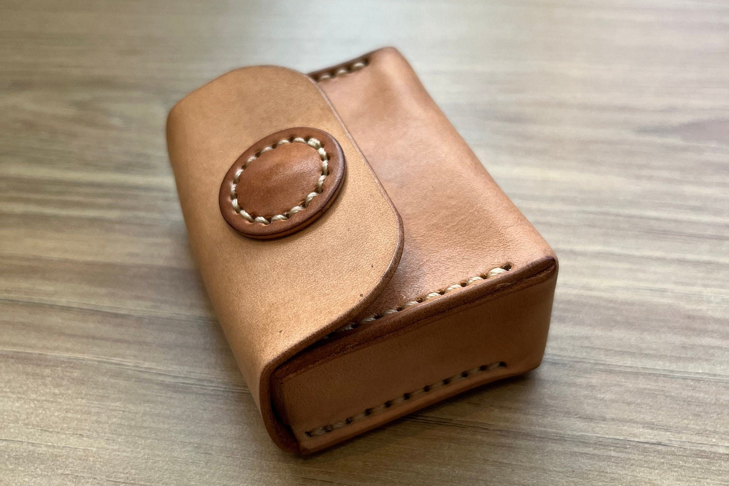 Close-up of 7mm length handmade leather coin bag. 