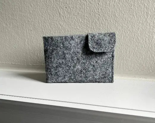 Leather card holder design with snapping button closure and card slots.