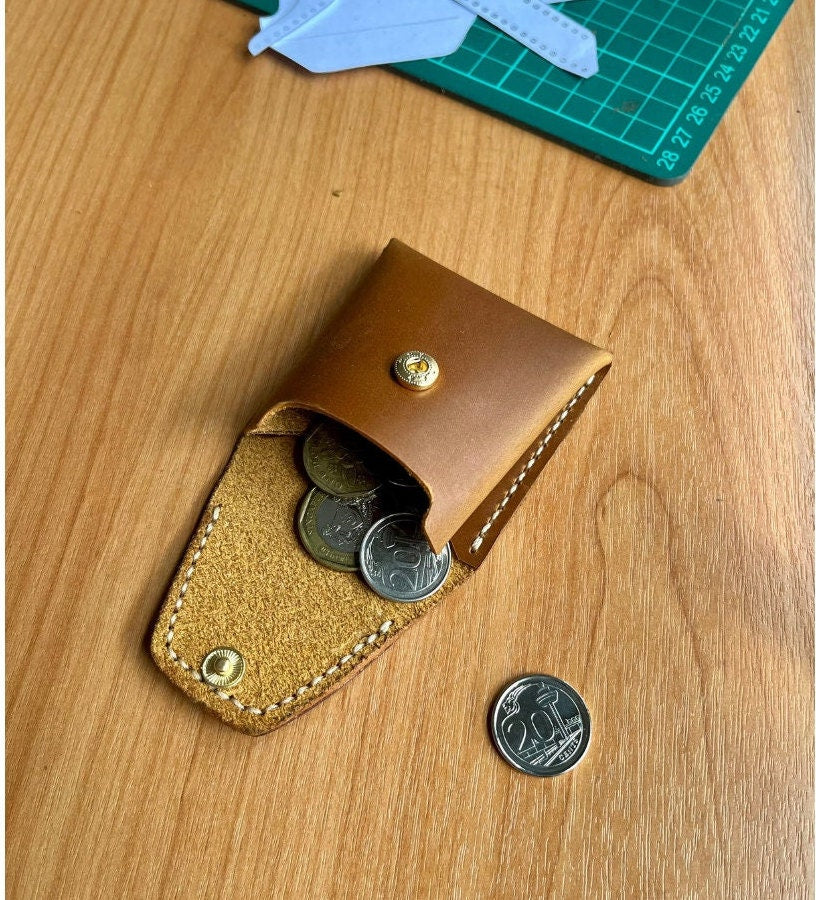 Front view of a leather pouch featuring a single snapping button as a closure.