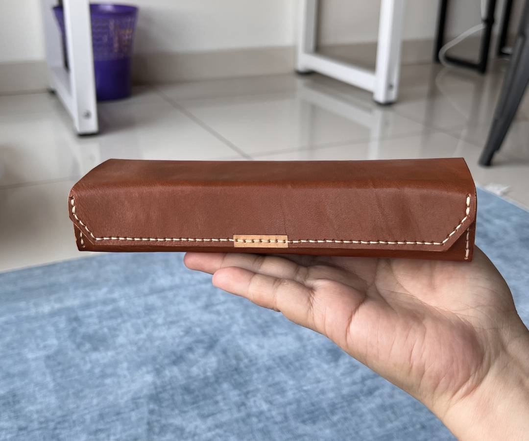 Hand holding an open leather case