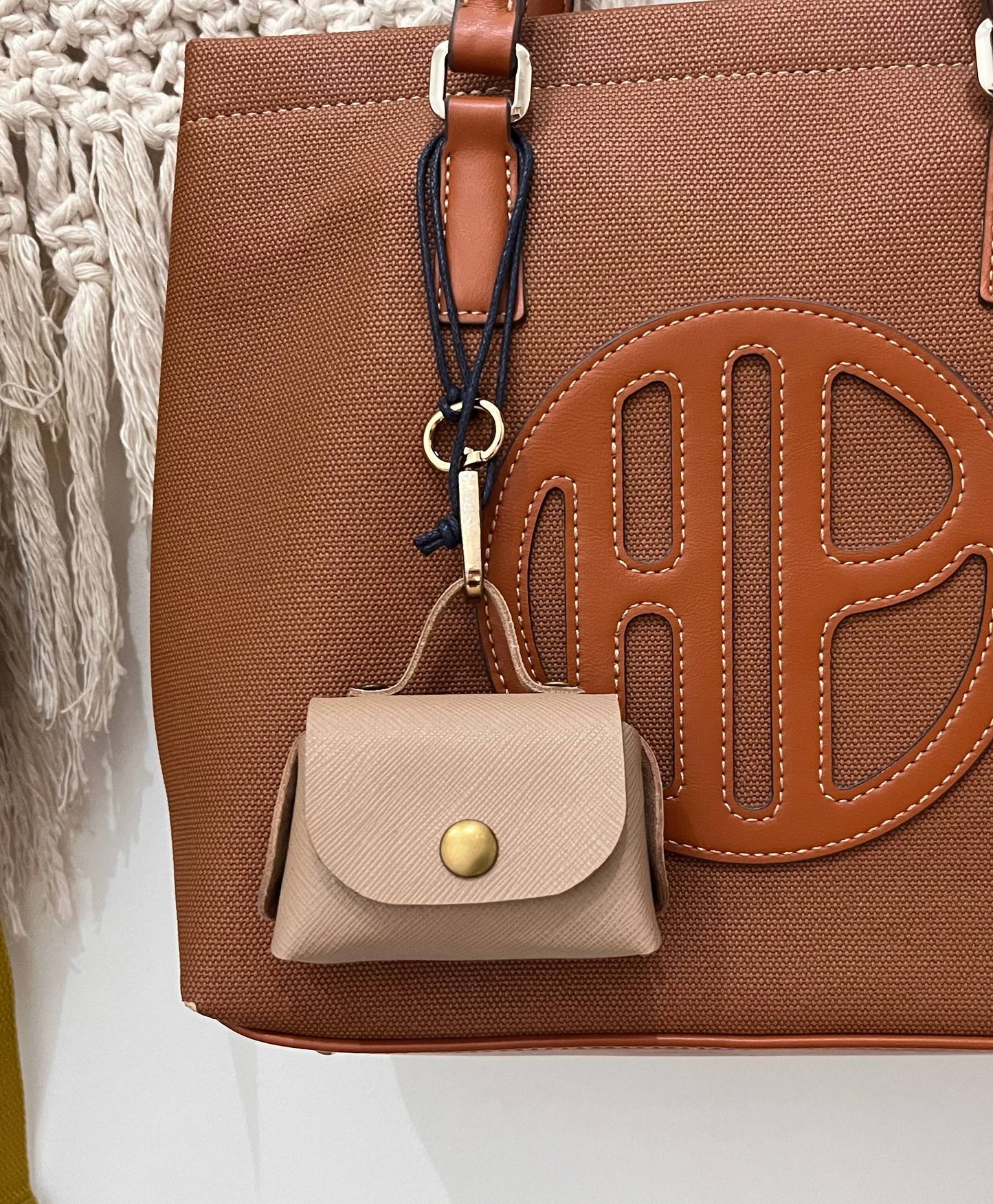 No-stitch Leather Air Pod Pro Case  with a matching keychain and beige pouch on a white background