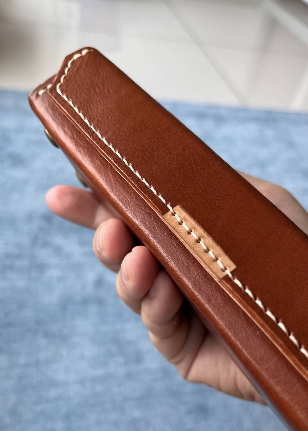 Close-up of leather case being held