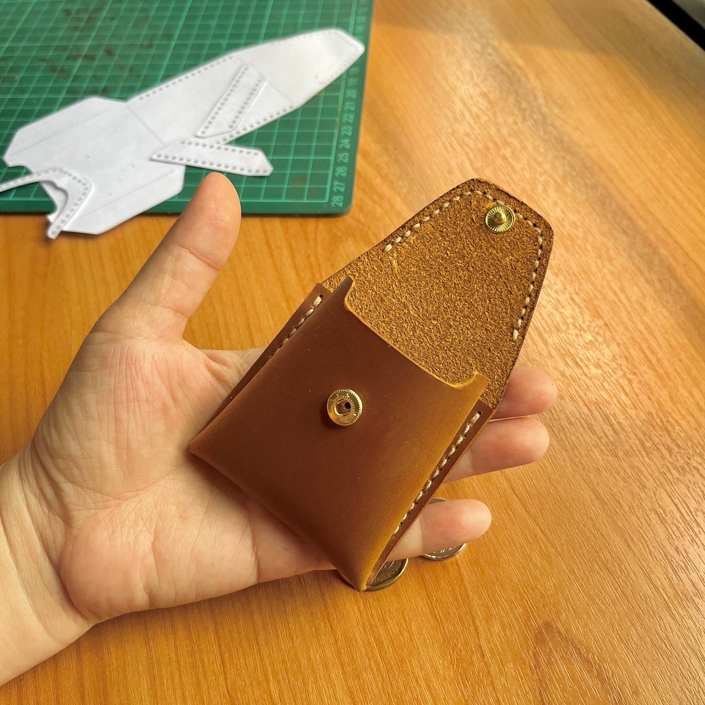 Beginner leathercraft tutorial image showing the assembly of a snap button purse.