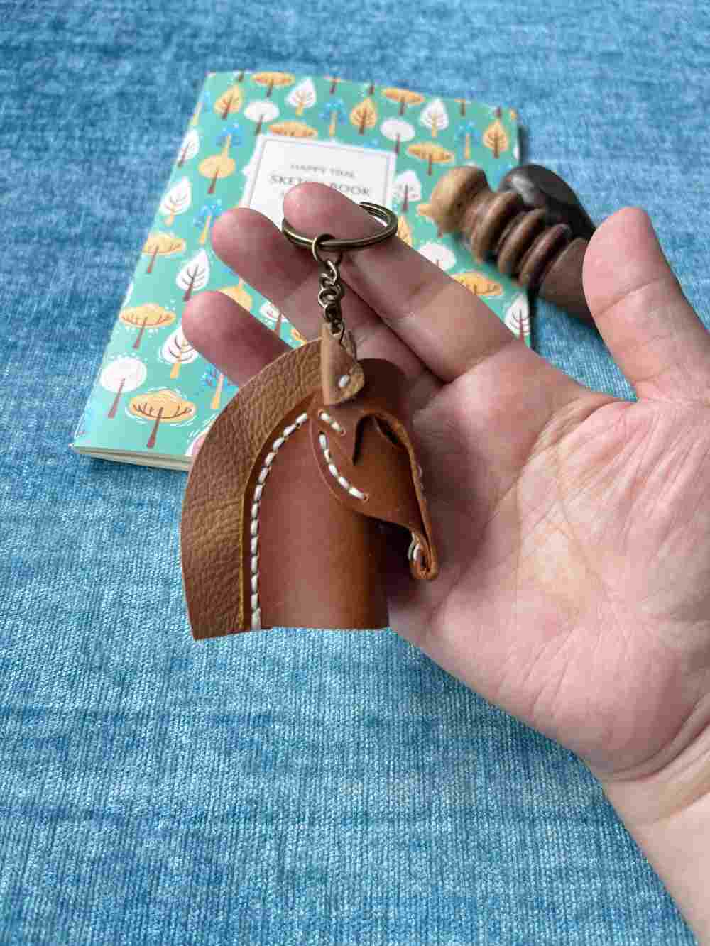 Simple yet elegant leather horse head silhouette keychain in caramel brown.