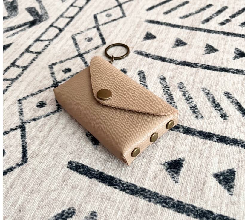 Front view of tan leather no-sew card holder with bronze snap and keyring