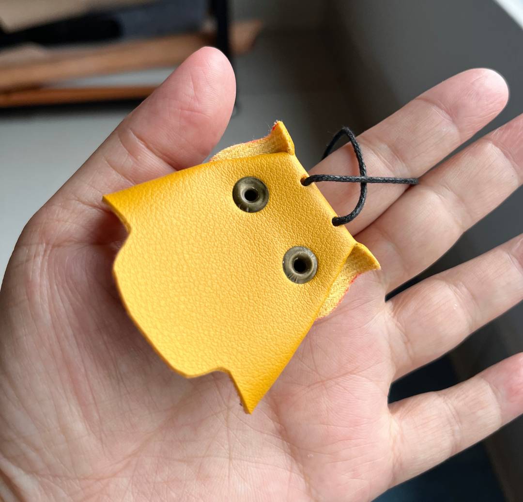 Close up of a handmade leather owl key organizer measuring 5x5cm with rivet details.