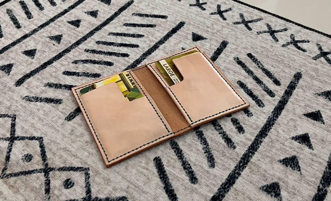 Front view of pocket size slim leather wallet with cards on a patterned rug