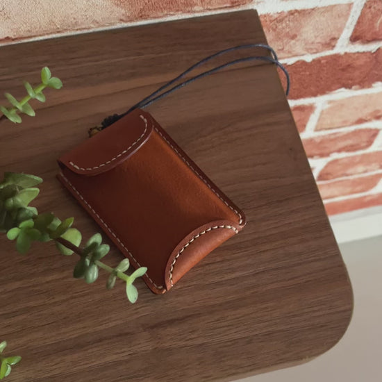 Minimalist leather card wallet attached to a black neck lanyard
