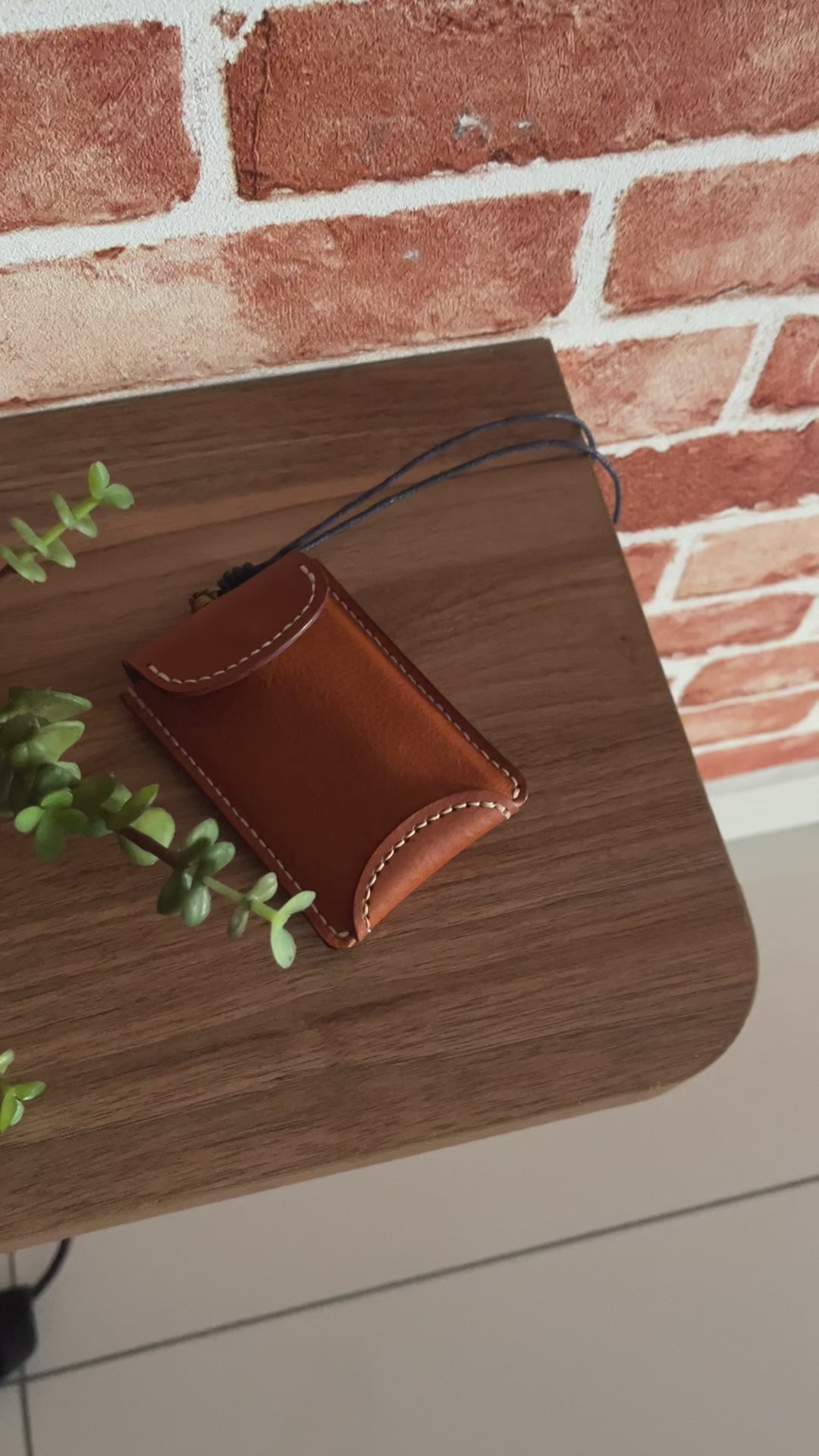 Minimalist leather card wallet attached to a black neck lanyard