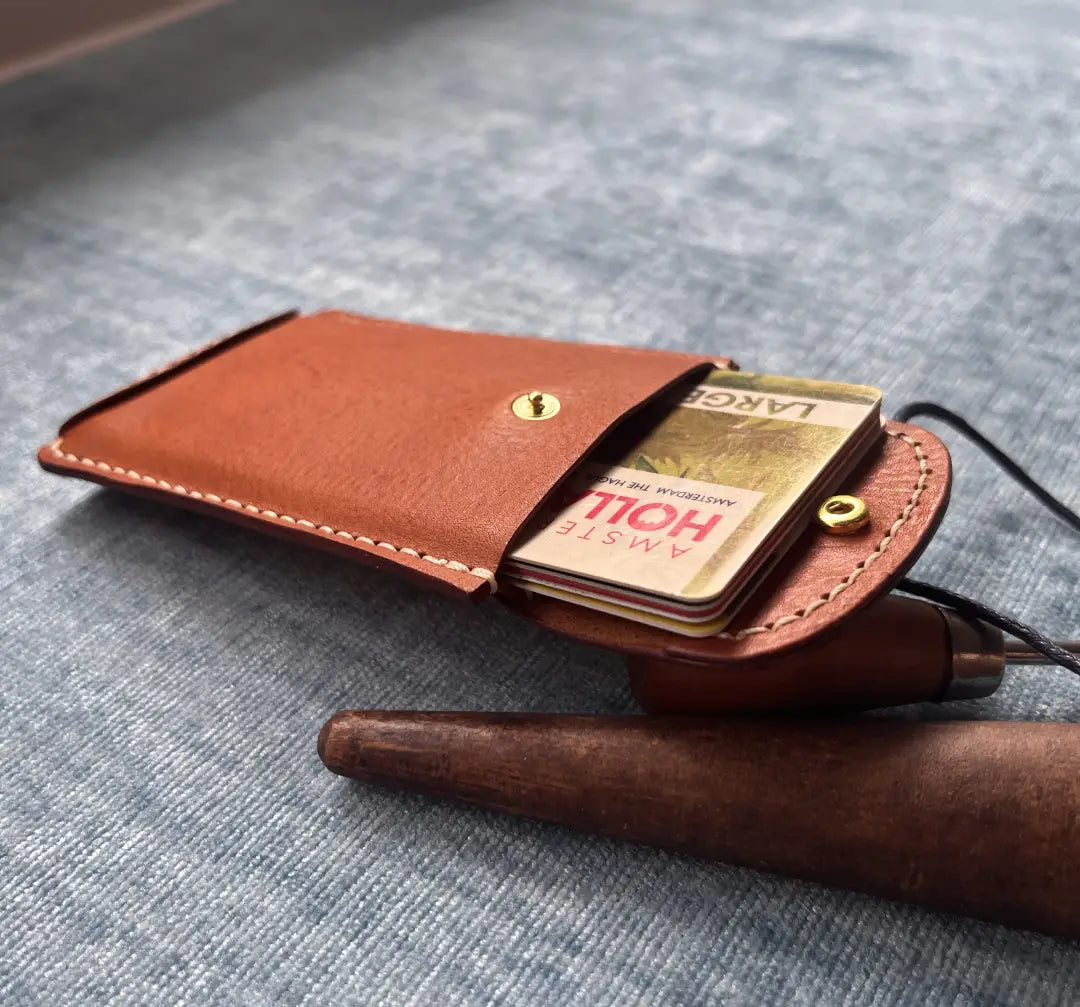 Slim leather wallet holding a few credit cards to show capacity and 6.8x9.8 cm dimensions for front pocket carry.