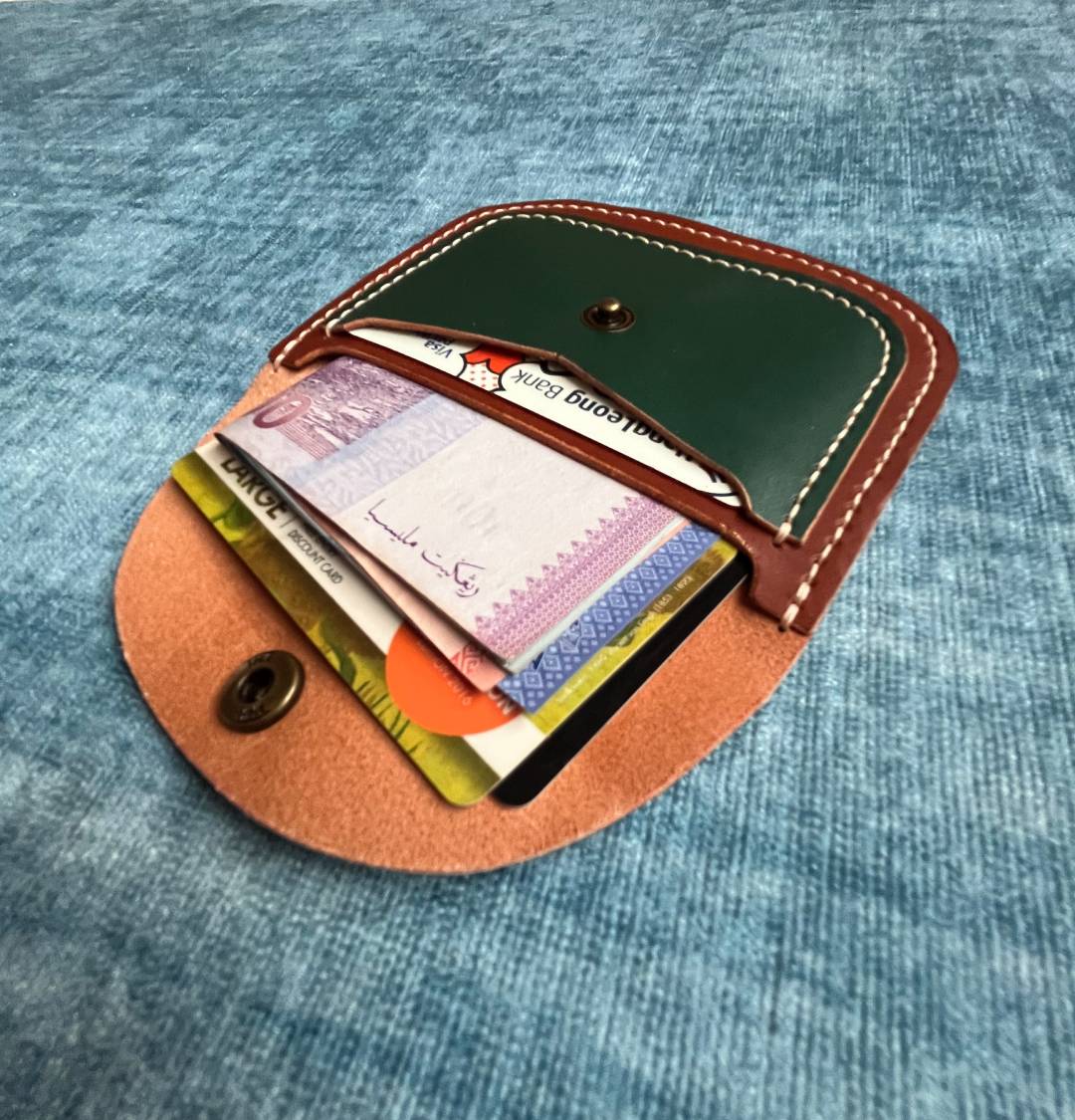 Interior view of the slim wallet holding four credit cards and folded cash.