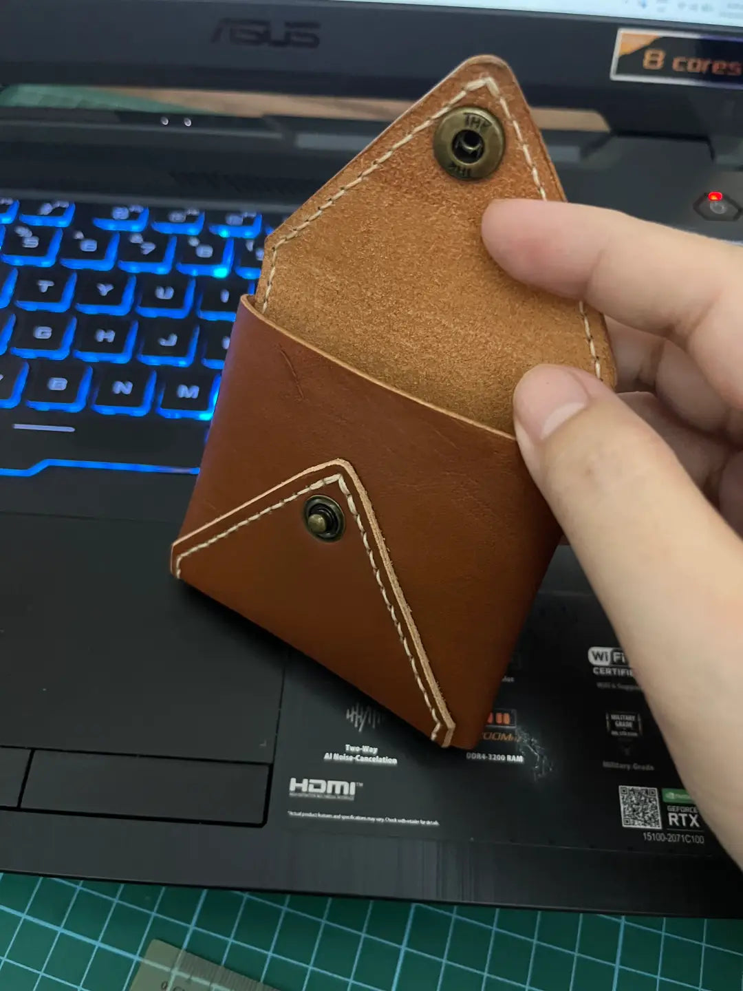 Small brown leather coin wallet held by a hand