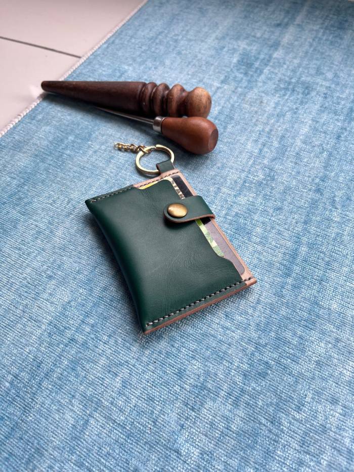 Close-up of snap button closure on a finished leather card holder wallet.