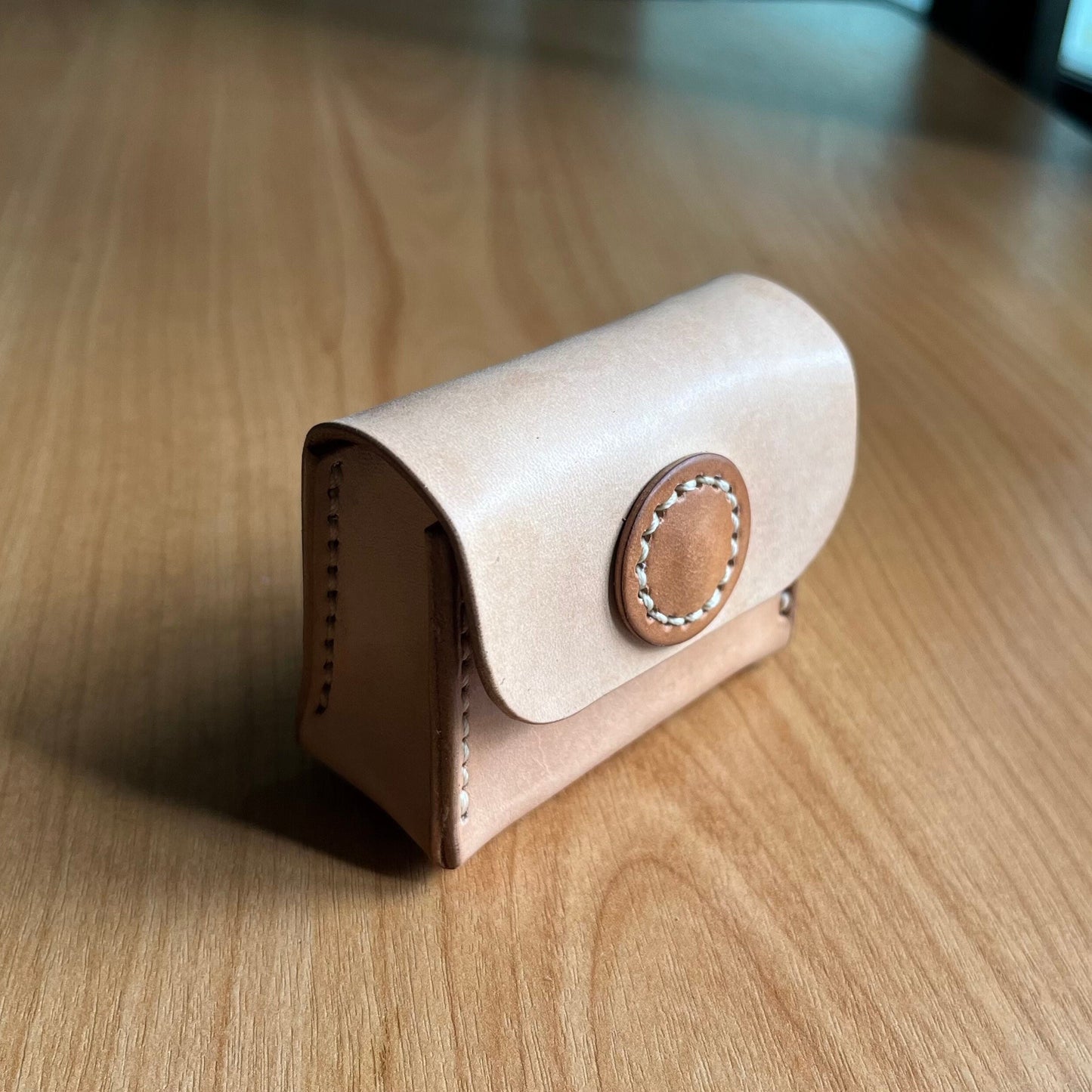 Small leather pouch with a snap closure designed for coins.