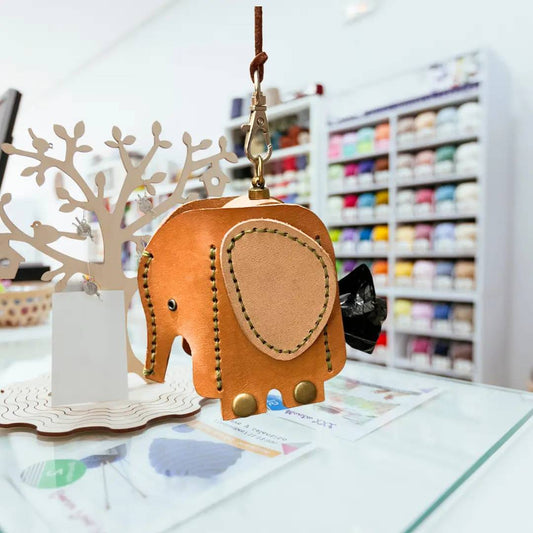 Close-up of an elephant leather dispenser showing the side opening for waste bag retrieval.